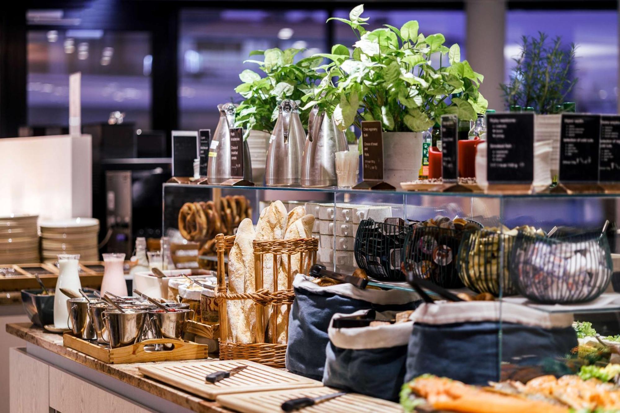 Radisson Blu Resort 슈비노우이스쳬 외부 사진 The photo depicts a beautifully arranged buffet or food display area. It features various items such as:

- Several glass or metal containers, possibly holding beverages or condiments.
- Fresh greenery in pots, suggesting a focus on natural elements.