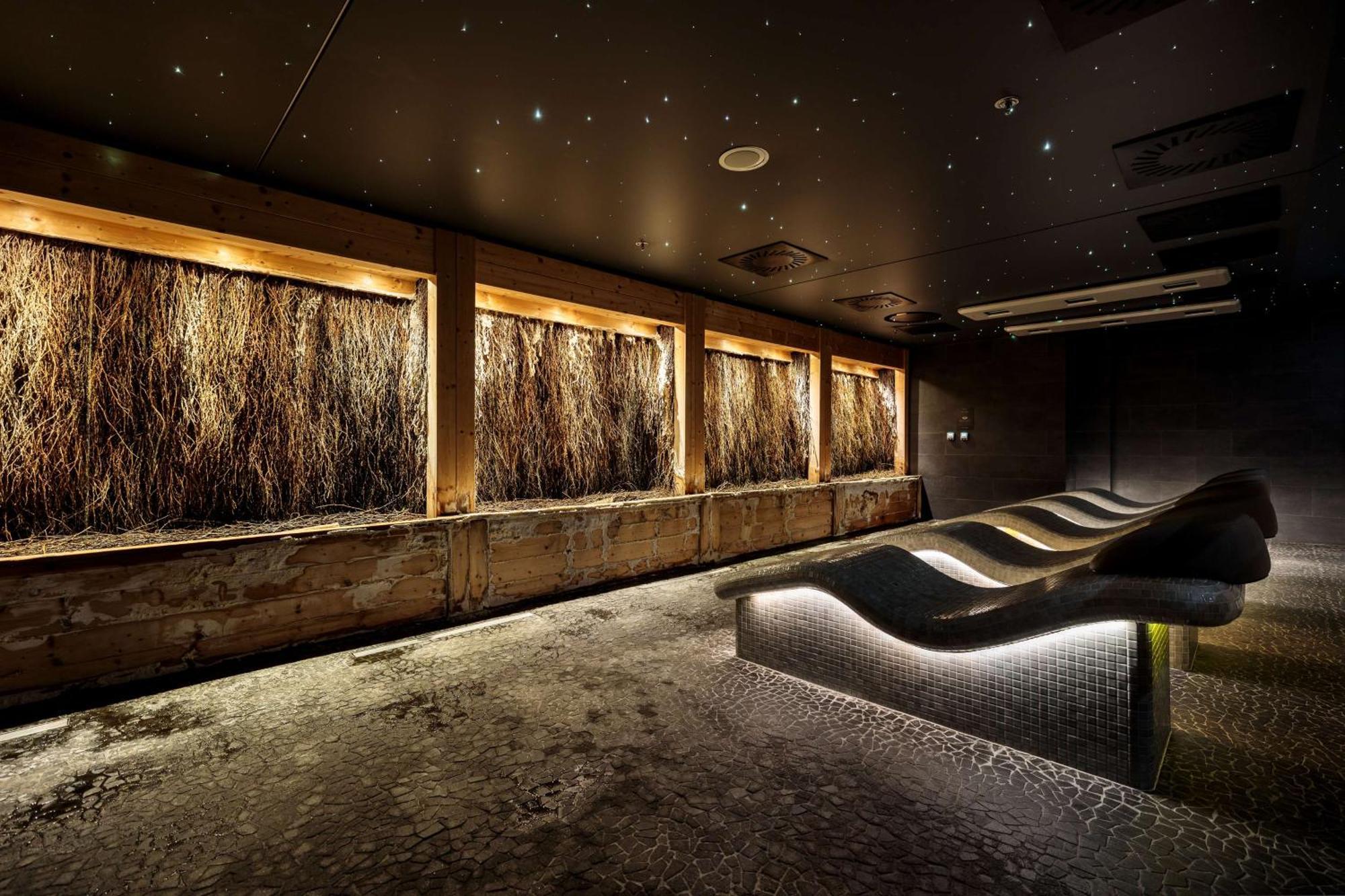 Radisson Blu Resort 슈비노우이스쳬 외부 사진 The photo depicts a modern, serene spa or relaxation space. It features several wooden-framed windows that showcase natural elements, possibly dried grass or plants, creating a calming atmosphere. The walls are dark, and the ceiling may have lights r